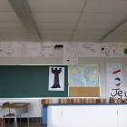 Une classe du secondaire avec plein de dessins sur le mur